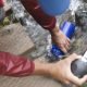 Female hiker with water filter filling water bottle in stream